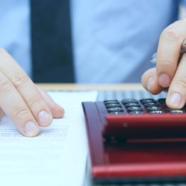 Businessman calculating fees with calculator