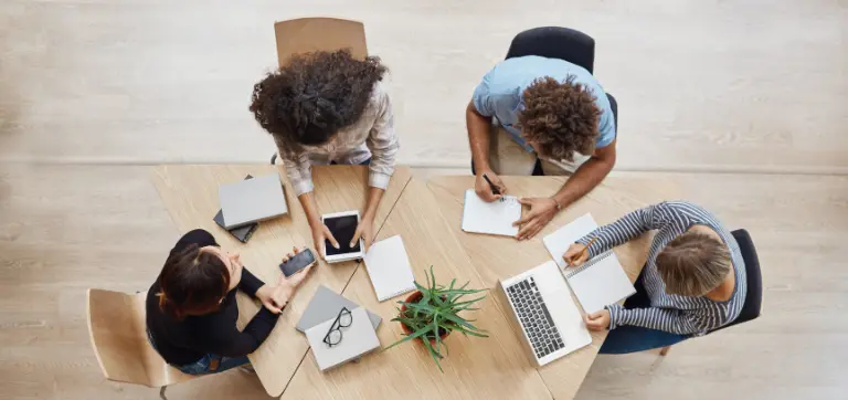 Imagen de arriba de personas laborando en una mesa