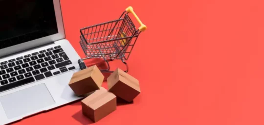 Carrito de compras y tarjeta de crédito en fondo rojo, renderizado en 3D.