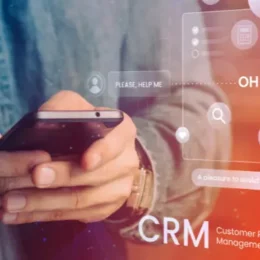 Persona que utiliza un teléfono inteligente con superposición de gráficos conceptuales de CRM (Customer Relationship Management).