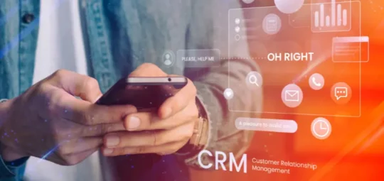 Persona que utiliza un teléfono inteligente con superposición de gráficos conceptuales de CRM (Customer Relationship Management).