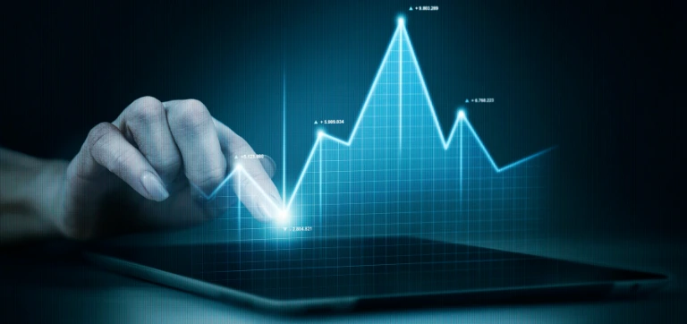 Una mano interactuando con una tableta digital que muestra datos de gráficos de líneas brillantes.